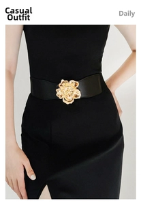 Gros plan sur une large ceinture élastique noire avec une boucle florale en métal doré