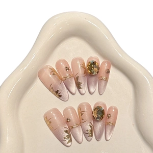 Handmade gold cat-eye press-on nails with luxury 3D crystals and gold butterfly charms