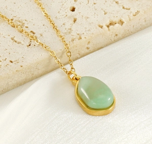 Close-up of 18K gold plated necklace with a polished light green natural stone pendant