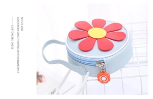Dettaglio del decoro a girasole e delle cuciture sulla mini borsa blu a tracolla