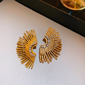 Macro detail of golden fan-shaped earrings with sparkling crystals and metal texture