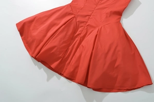 Détail d'une mini robe rouge avec un ourlet plissé en ligne A et une texture de tissu lisse
