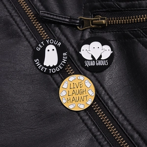 Detailed view of Halloween ghost enamel pins on black leather jacket with creative text