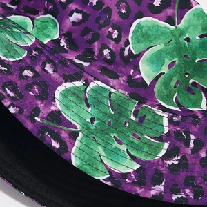 Dettaglio di un cappello a secchiello con stampa leopardata tropicale e cuciture fini