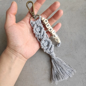 Detail of handmade macramé keychain with grey tassels and Be Kind letter beads