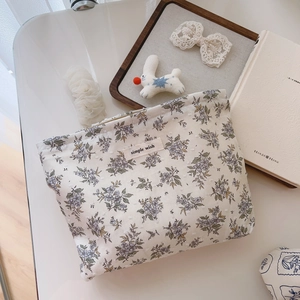 Floral cotton makeup bag with 'simple wish' label shown in a cozy flat lay setting