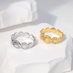 Detail view of gold and silver sunburst texture rings on minimalist stone backdrop