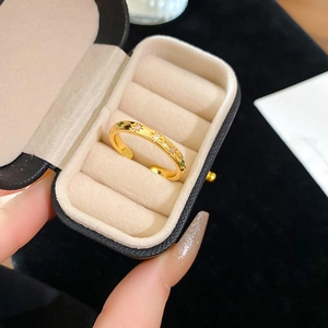 Detailed close-up of golden star-engraved ring with green zircon in a gift box