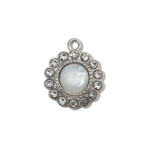 Detailed view of silver sunburst pendant with white shell inlay and zircon accents
