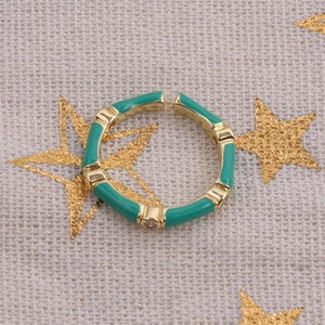 Macro detail of adjustable gold bamboo ring with emerald enamel and crystals