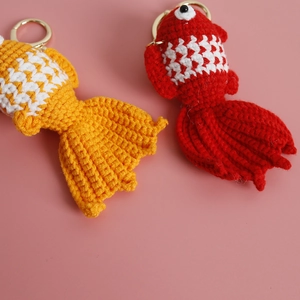 Handmade crochet goldfish keychains in orange and red yarn with golden rings