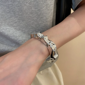 Detailed view of silver irregular lava texture cuff bracelet worn by a model