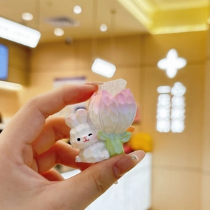 Macro view of cute faceted crystal rabbit with pink tulip desktop decorative ornament