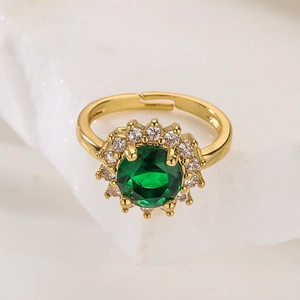 18K gold plated flower ring with green zircon and white crystals on stone background