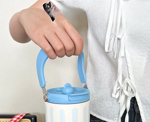 Detail of the ergonomic light blue curved handle on a striped large insulated tumbler