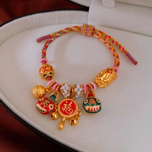 Détail du bracelet en cordon tressé avec PiXiu doré et pendentif de caractère Fu
