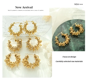Detailed close-up of gold geometric hoop earrings with unique spiral wire design