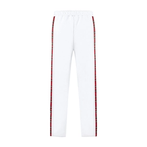 Detail of white trousers showing red and green plaid side tape and elastic waistband