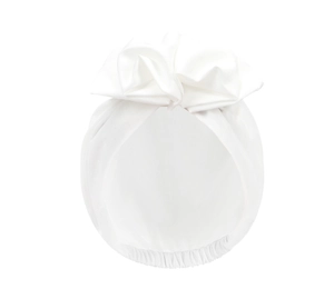 Close-up of white silk satin turban with a large elegant bow and pleated texture