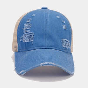 Close-up of vintage distressed denim trucker hat with blue fabric and beige mesh detailing