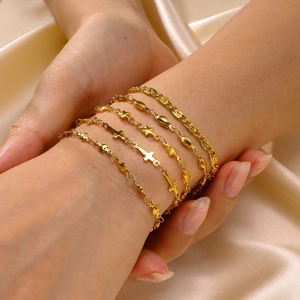 Set of 5 minimalist 18K gold plated star and heart charm bracelets on silk background