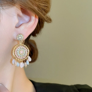 Detail of bohemian mandala earrings with colorful teardrop beads on female model