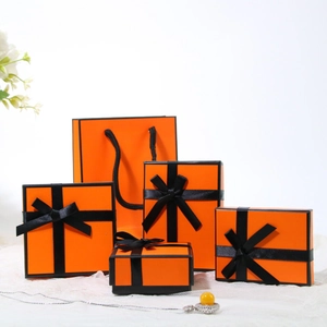 Detail of premium orange jewelry gift box set with elegant black ribbon bows and bag