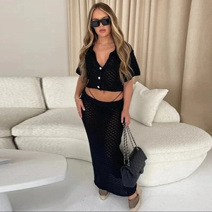 Dettaglio del set in maglia nera con top a bottoni con scollo a V e gonna slim coordinata