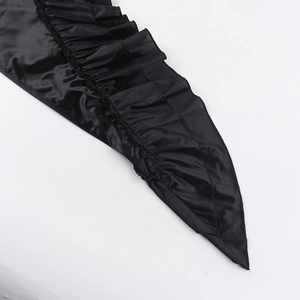 Détail du tissu en satin noir élégant avec des bords à volants et des finitions de couture fines