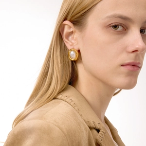 Elegant 18K gold plated oval stud earrings with white resin pearls on a model
