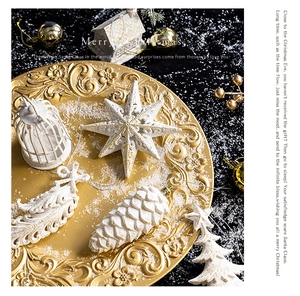Luxurious white glitter star and pinecone ornaments on an embossed gold tray