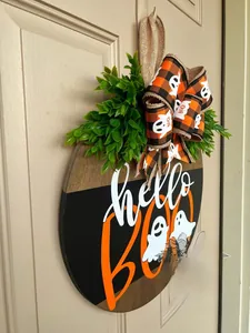 Detail of hello BOO wooden Halloween door wreath with ghosts and ribbon hanging on a door