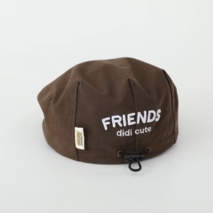 Detail of brown children's beret featuring white FRIENDS embroidery and adjustable drawstring