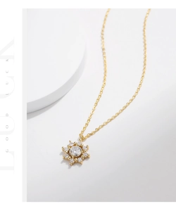 Gros plan d'un collier pendentif flocon en or avec un centre en moissanite brillant