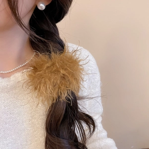 Close-up of fluffy brown plush hair tie on braided hairstyle with elegant winter style