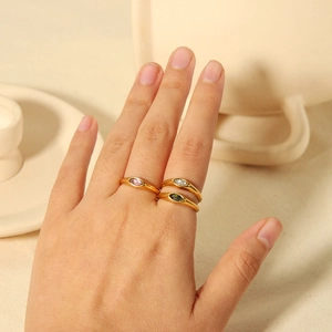 Three-piece stackable 18K gold stainless steel rings with marquise cut gemstones on finger