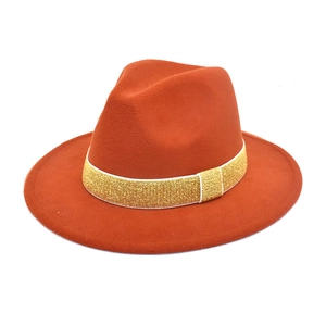 Detailed view of rust orange wool fedora with a shimmering gold glitter band embellishment