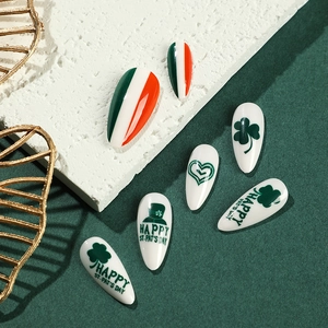 St. Patrick's Day press-on nails featuring green shamrocks and festive heart patterns