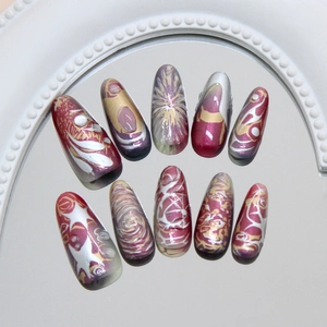 Deep purple and gold 3D press-on nails in long almond shape on a mirrored surface