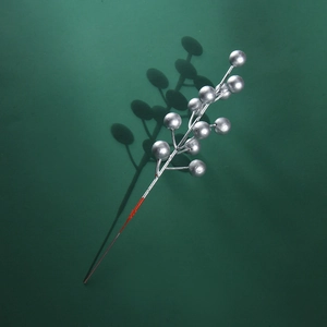 Single silver faux berry branch centerpiece for Christmas table decor on green background