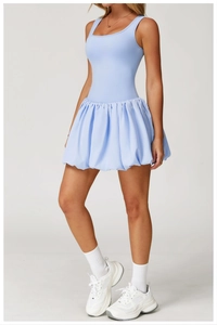 Detail of light blue sleeveless athletic dress featuring a pleated bubble hem and U-neck