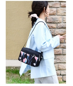 Outdoor shot showing side view of floral oxford cloth crossbody bag with tulip pattern