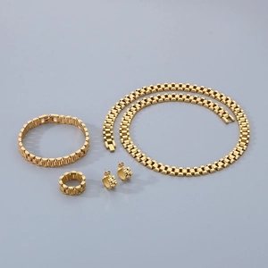 Vue à plat d'un ensemble de bijoux 4 pièces en acier doré avec maillons de montre