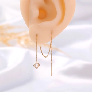 Detail of gold threader earrings with zircon square pendant on a display model
