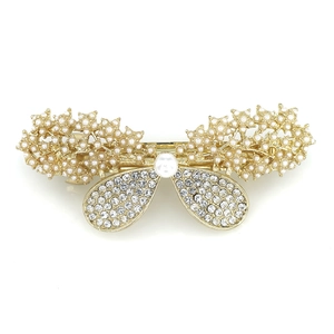 Elegant gold bow hair clip with white imitation pearls and rhinestones on white background