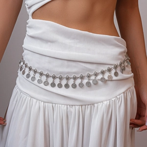Detailed view of vintage silver coin belt with bohemian flower metal tassels on clothing