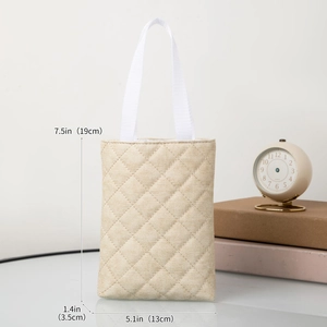 Detailed view of beige quilted tote bag showing dimensions 19x13x3.5cm and woven texture
