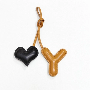 Dettaglio del ciondolo per borsa in pelle cucito a mano a cuore e lettera Y di lusso