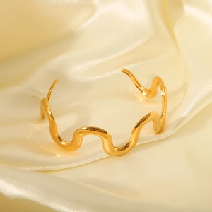 Chic 18K gold stainless steel wavy bangle bracelet for women on golden silk background