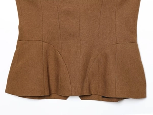 Close-up of brown linen blend vest showing fabric texture and structured hem stitching